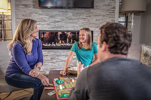 family around table by fireplace