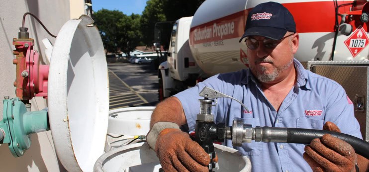 worker servicing propane tank