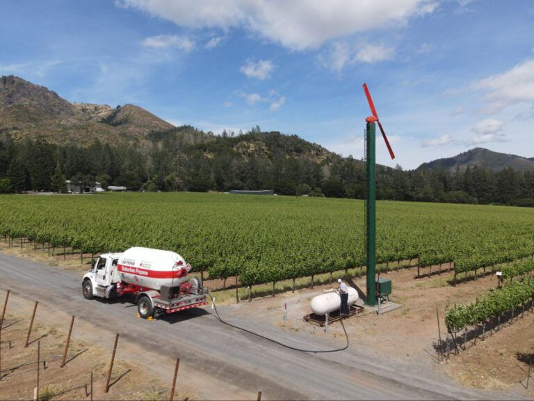 A Suburban Propane truck delivers propane to a farm in a rural area