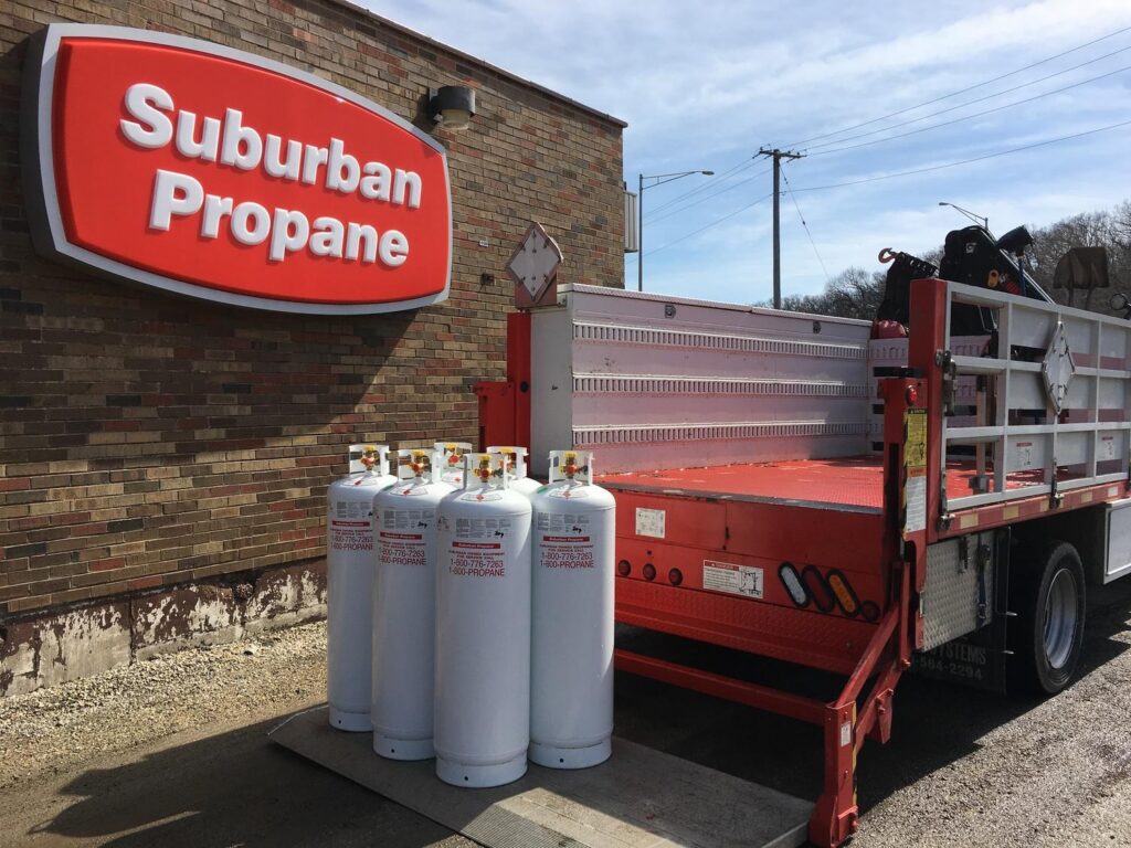 A group of propane tanks sitting on the back of a Suburban Propane Delivery Truck