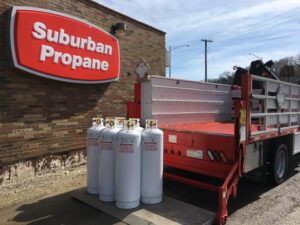 A group of propane tanks sitting on the back of a Suburban Propane Delivery Truck
