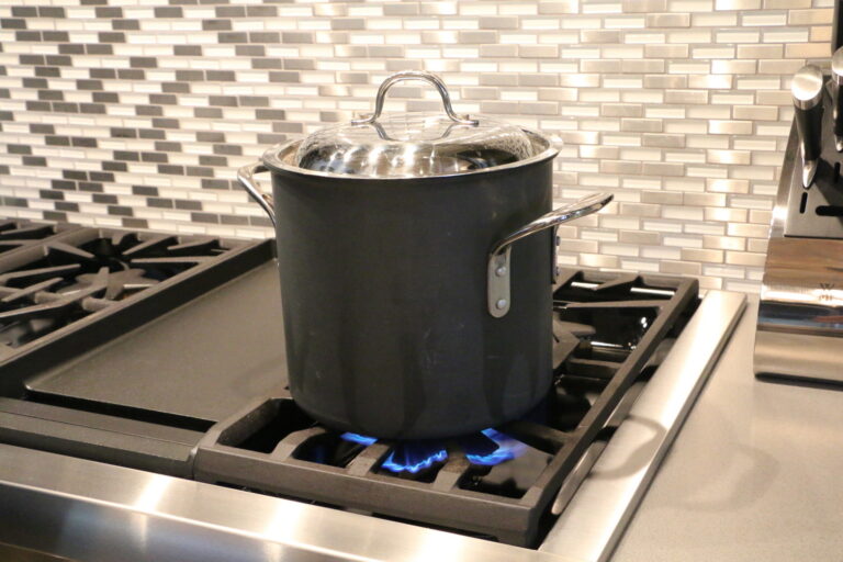 A pot cooking on a propane stove