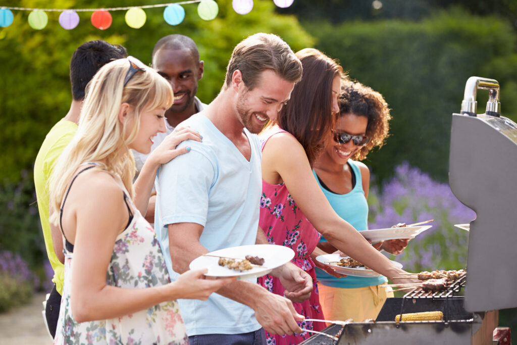 Group Of Friends Having Outdoor Barbeque At Home