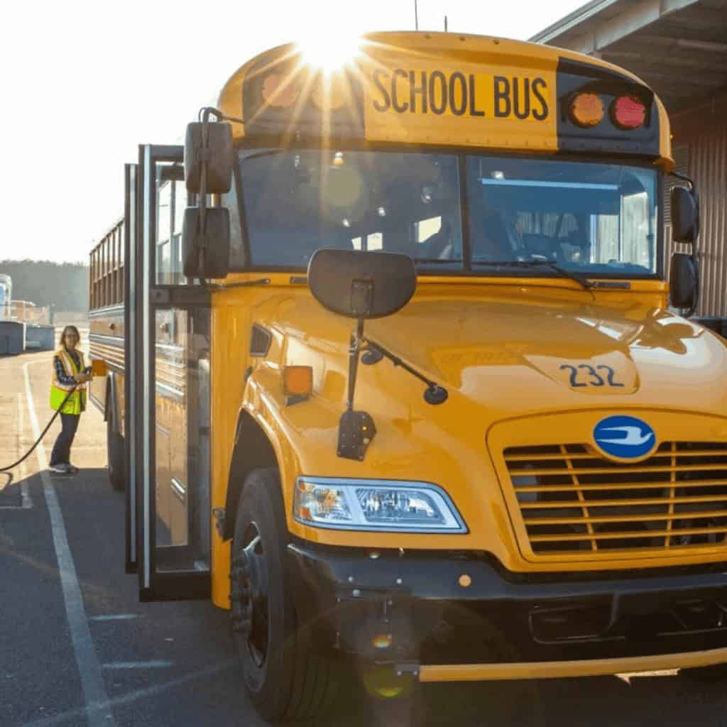 school bus with driver outside of it
